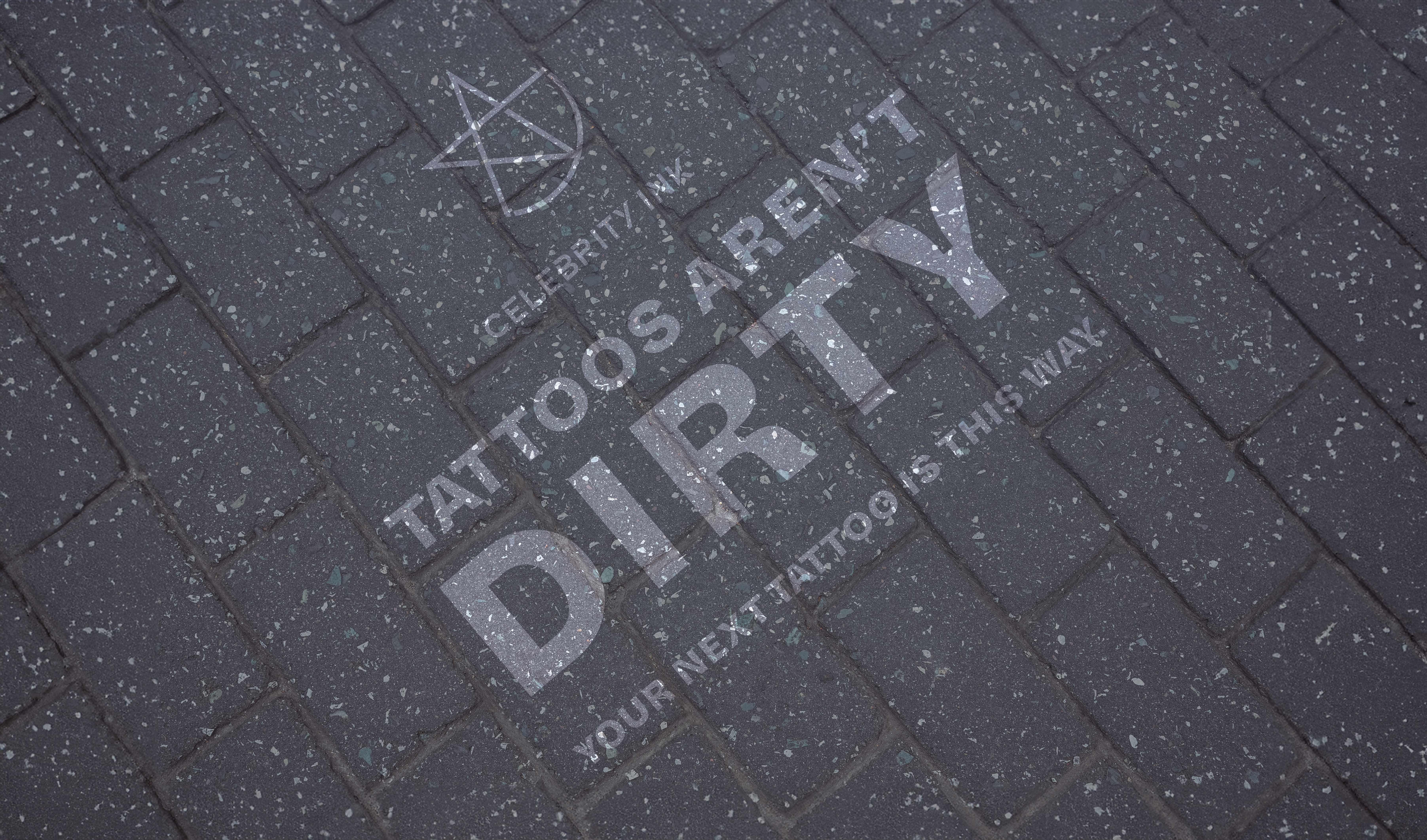 Reverse graffiti stencil cleaned into a cobblestone footpath